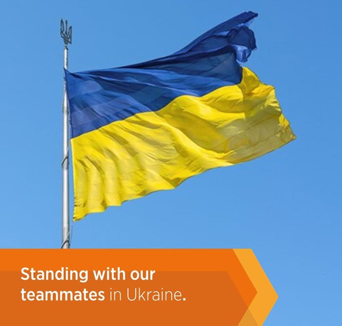 Grafika przedstawiająca flagę Ukrainy oraz napis biały na pomarańczowym tle Etex : Standing with our teammates in Ukraine