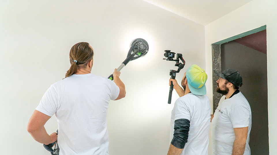 Wykonawy Siniat przygotowujący ścianę do malowania – szlifowanie z wykorzystaniem maszyny Planex od Festool. 3 instalatorów suchej zabudowy