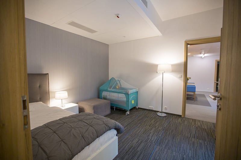 Pokój w domu Ronalda McDonalda – po lewej stronie podwójne łóżko, w głębi łóżeczko dziecięce. 